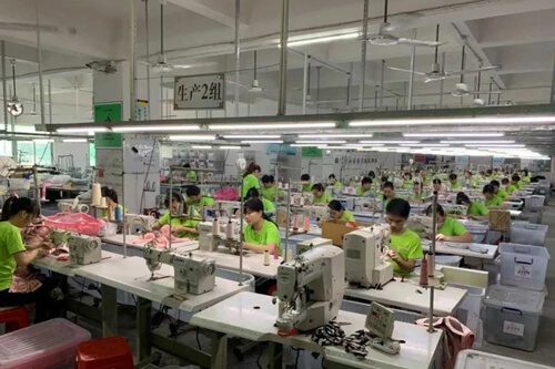 عامل مصنع يخيط حمالة صدر على آلة الخياطة الصناعية.