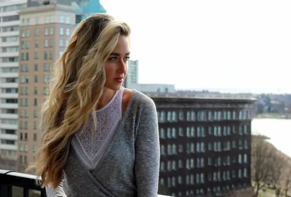 Woman wearing a high-neck lace bralette under a shirt