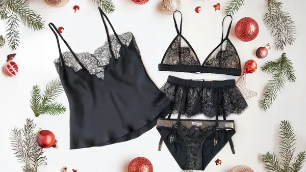 Uma tábua de humor para lingerie de Natal com renda branca, detalhes de prata, flocos de neve e veludo vermelho rico.