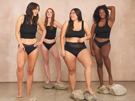 Eine vielfältige Gruppe von Frauen mit unterschiedlichen Körpertypen tragen glücklich bequeme, minimalistische Braletten und Unterwäsche.