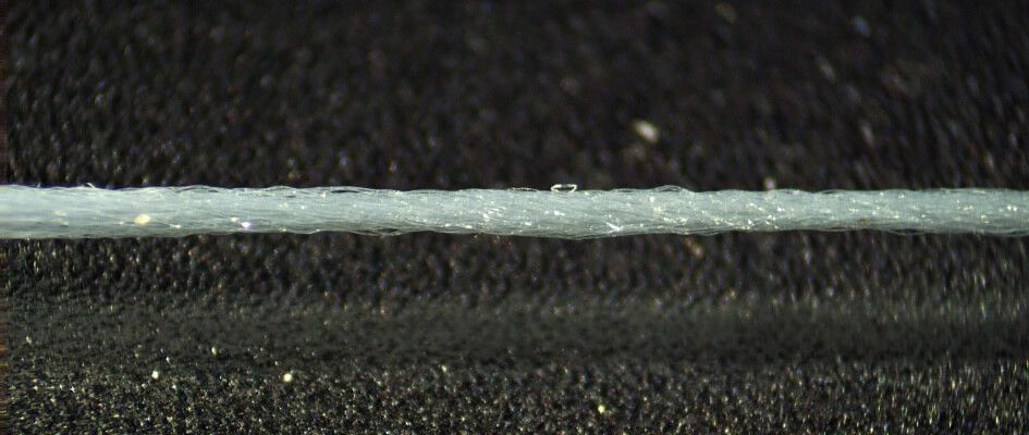 لقطة ماكرو لخياطة إبرة مع خيط نايلون ناعم ورقيق.