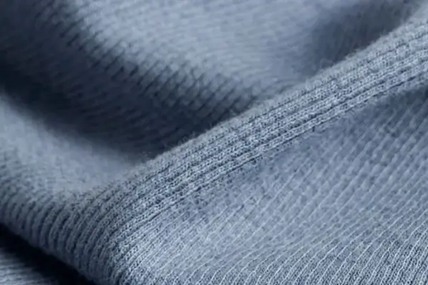 A close-up of a high-performance technical fabric, showing its dense, powerful knit structure.