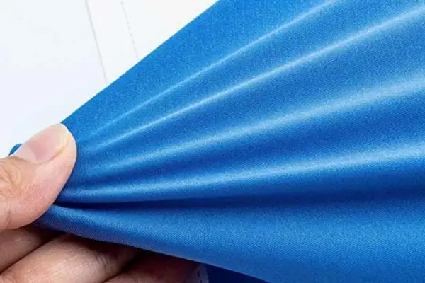 A close-up of someone stretching a piece of old, worn-out elastic fabric that doesn't snap back.